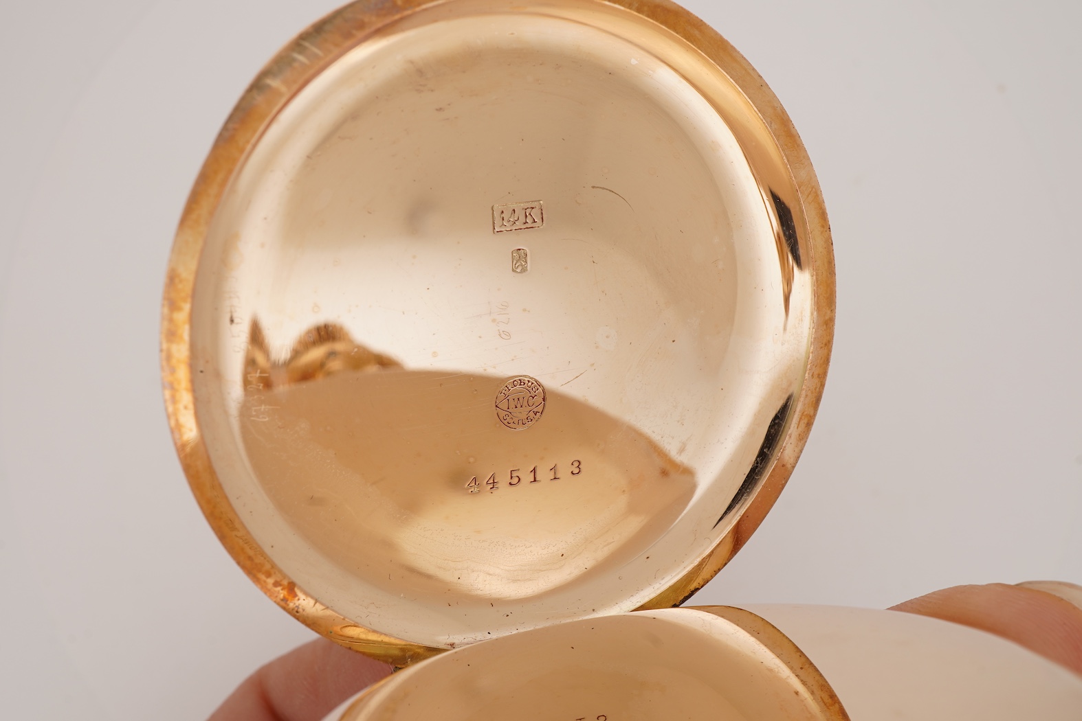 An early 20th century International Watch Company engine turned 14k yellow metal open faced keyless lever pocket watch, together with a Viennese? two colour yellow metal albert, maker's mark, LE